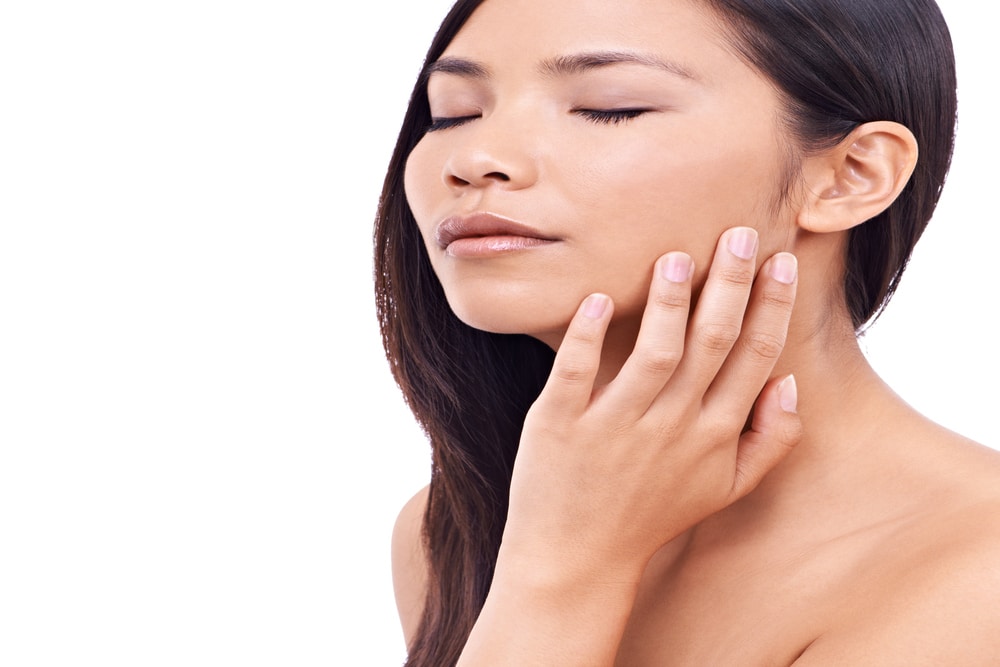 Woman touches her soft, smooth skin after microneedling