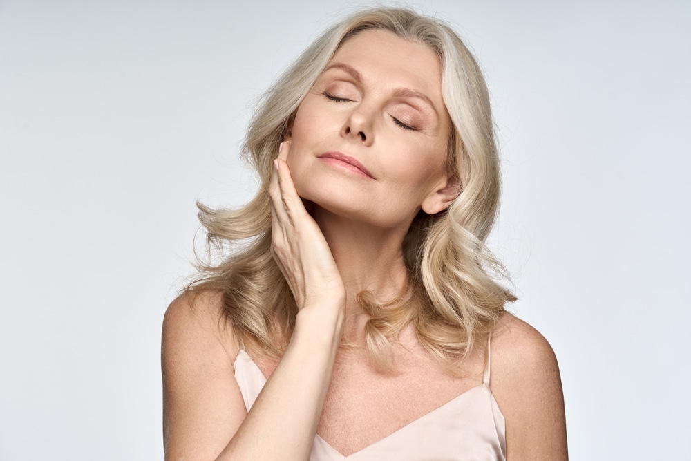 Beautiful older woman touching her jawline